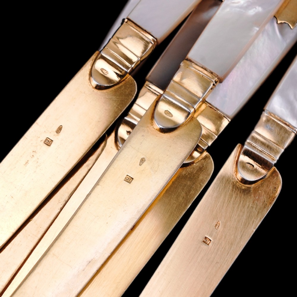 A set of six 19th-century fruit knives featuring silver-gilt blades and mother-of-pearl handles inlaid with small shield motifs. View XVII