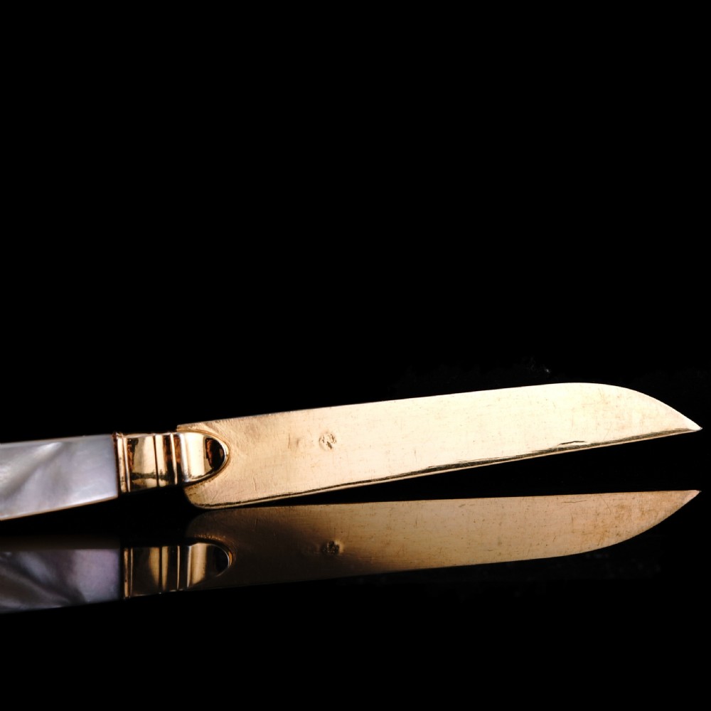 A set of six 19th-century fruit knives featuring silver-gilt blades and mother-of-pearl handles inlaid with small shield motifs. View XX