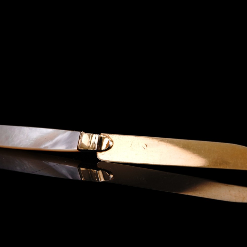 A set of six 19th-century fruit knives featuring silver-gilt blades and mother-of-pearl handles inlaid with small shield motifs. View XXI