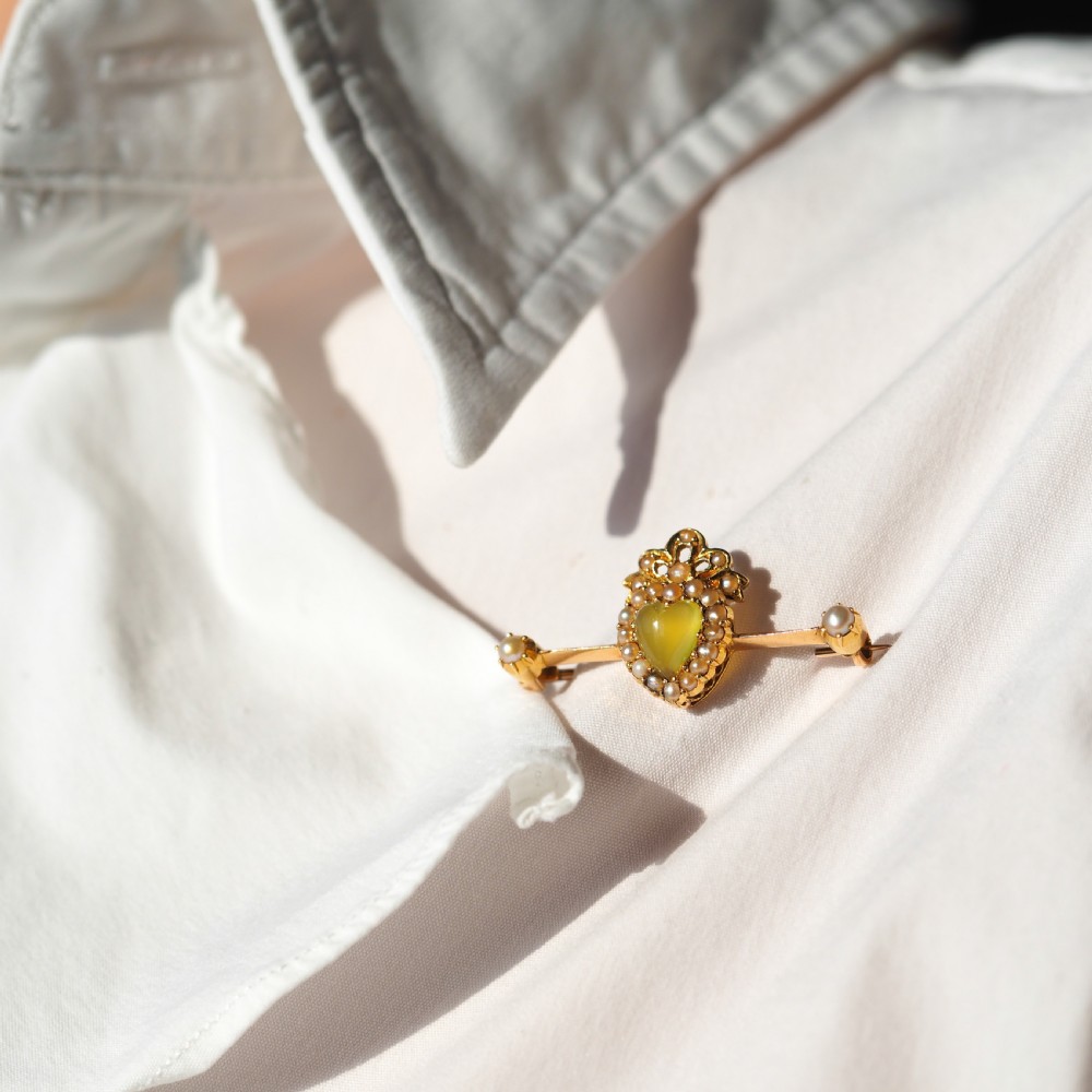 A late Victorian 15ct gold bar brooch featuring a central heart-shaped green chalcedony cabochon framed by seed pearls. View VII