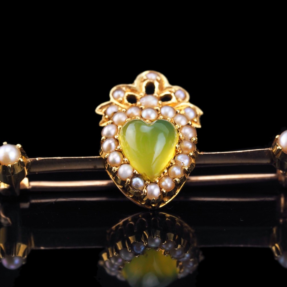 A late Victorian 15ct gold bar brooch featuring a central heart-shaped green chalcedony cabochon framed by seed pearls. View IX