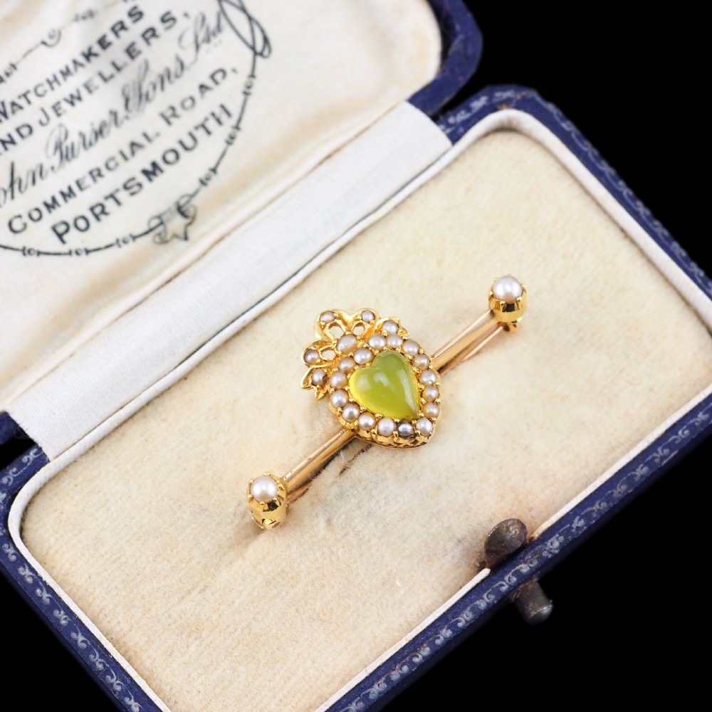 A late Victorian 15ct gold bar brooch featuring a central heart-shaped green chalcedony cabochon framed by seed pearls. View XI