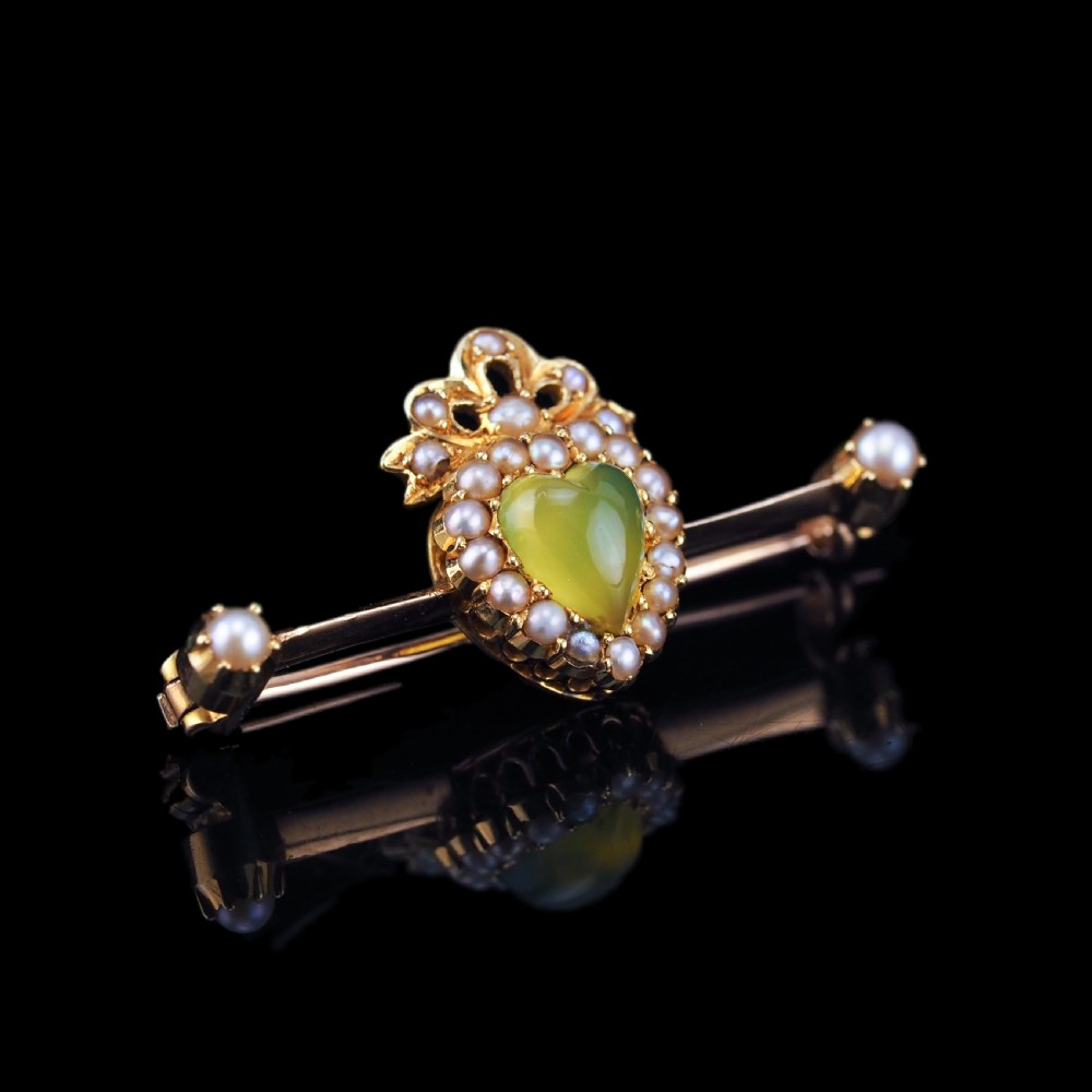 A late Victorian 15ct gold bar brooch featuring a central heart-shaped green chalcedony cabochon framed by seed pearls. View XIII