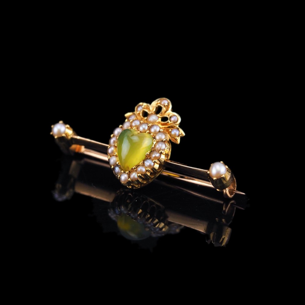 A late Victorian 15ct gold bar brooch featuring a central heart-shaped green chalcedony cabochon framed by seed pearls. View XIV