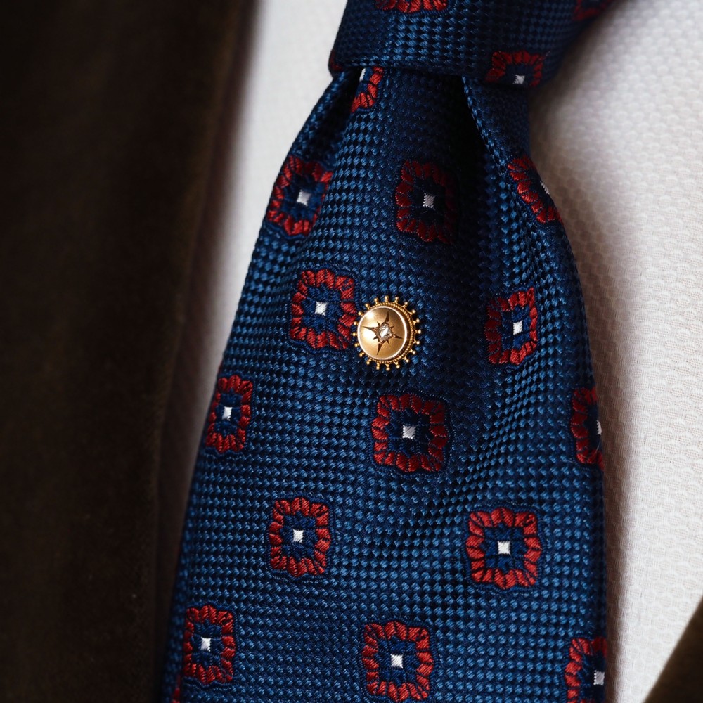 A Victorian 14ct gold stick pin featuring a round head with a star-set diamond and a beaded granulated outer border. View XI