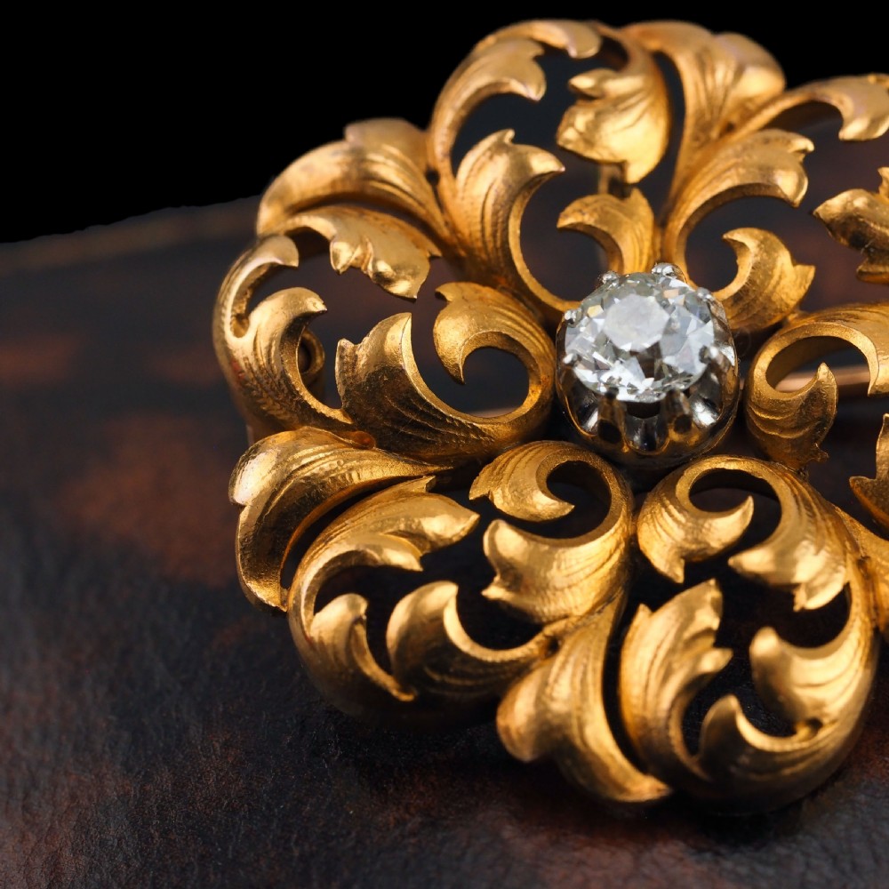 An 18ct yellow gold Victorian pendant brooch with openwork acanthus leaf scrollwork and a central round diamond. View II