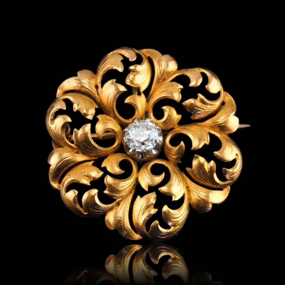 An 18ct yellow gold Victorian pendant brooch with openwork acanthus leaf scrollwork and a central round diamond. View IV