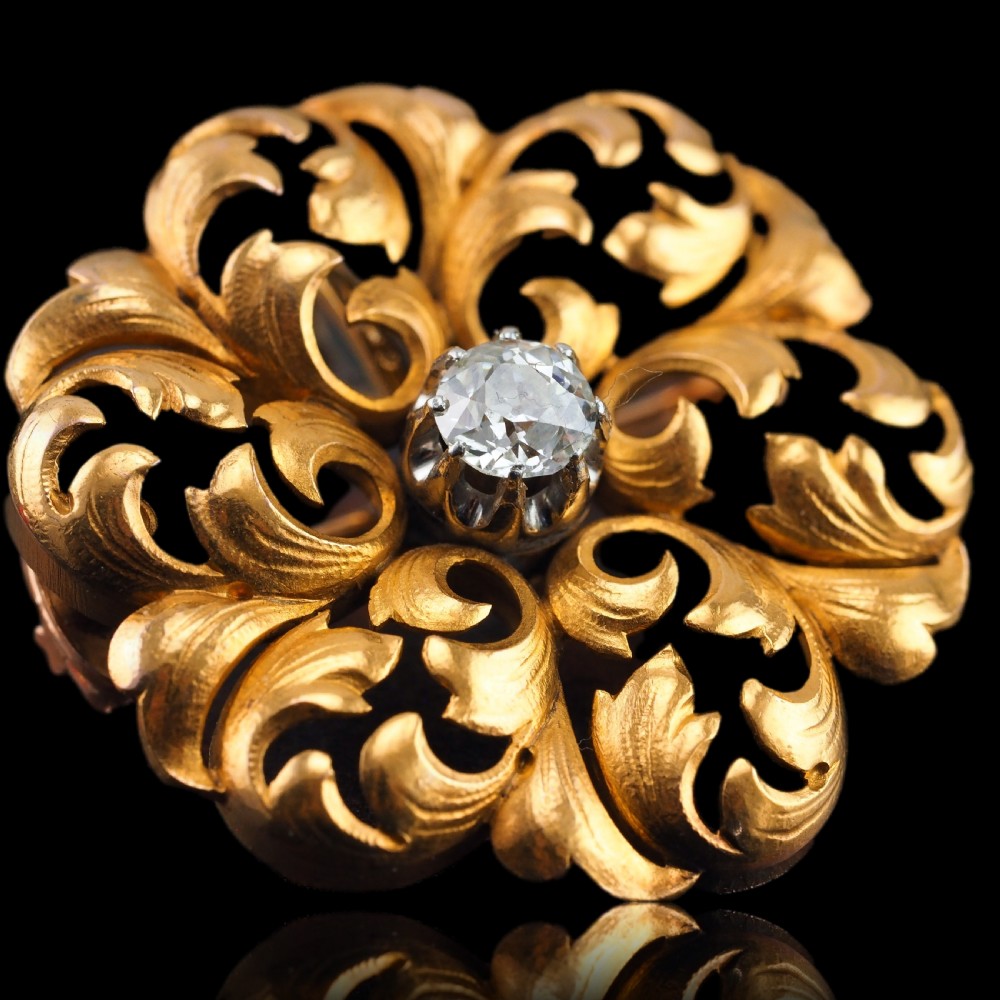 An 18ct yellow gold Victorian pendant brooch with openwork acanthus leaf scrollwork and a central round diamond. View V