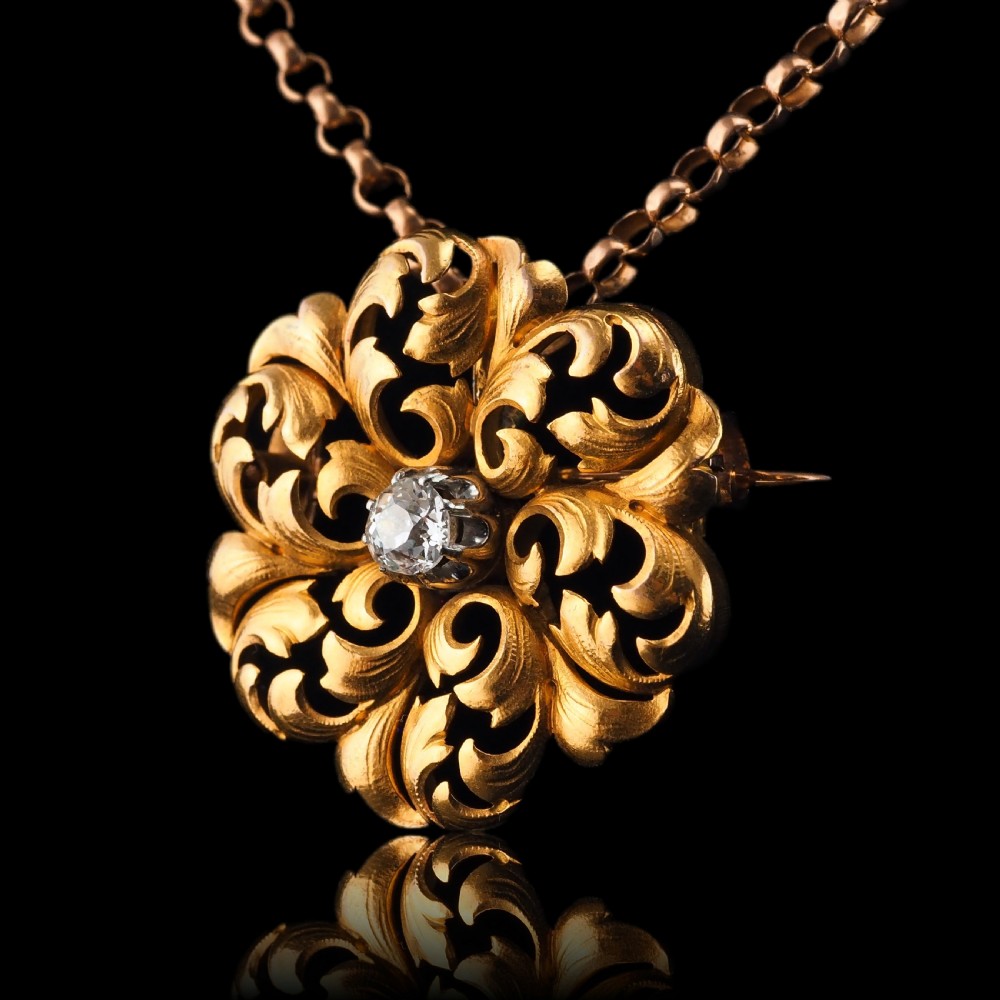 An 18ct yellow gold Victorian pendant brooch with openwork acanthus leaf scrollwork and a central round diamond. View VII