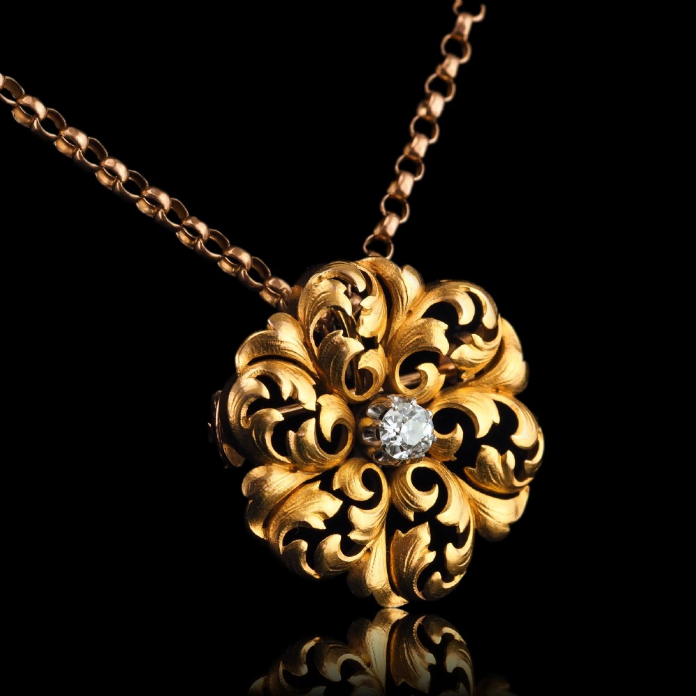 An 18ct yellow gold Victorian pendant brooch with openwork acanthus leaf scrollwork and a central round diamond. View IX