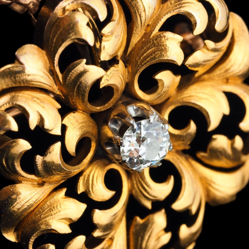 An 18ct yellow gold Victorian pendant brooch with openwork acanthus leaf scrollwork and a central round diamond. View X