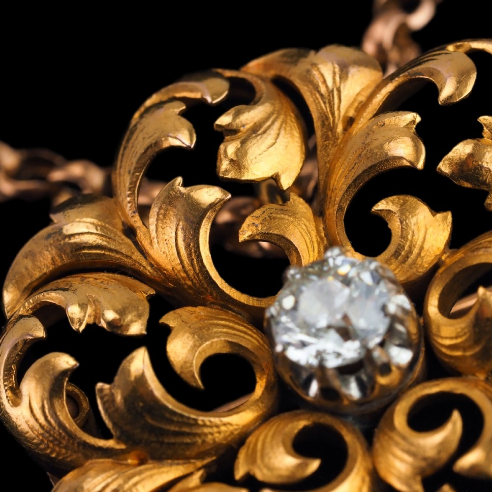An 18ct yellow gold Victorian pendant brooch with openwork acanthus leaf scrollwork and a central round diamond. View XIV