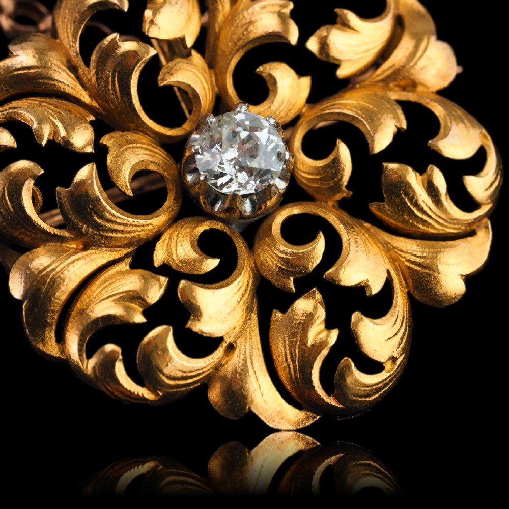 An 18ct yellow gold Victorian pendant brooch with openwork acanthus leaf scrollwork and a central round diamond. View XV