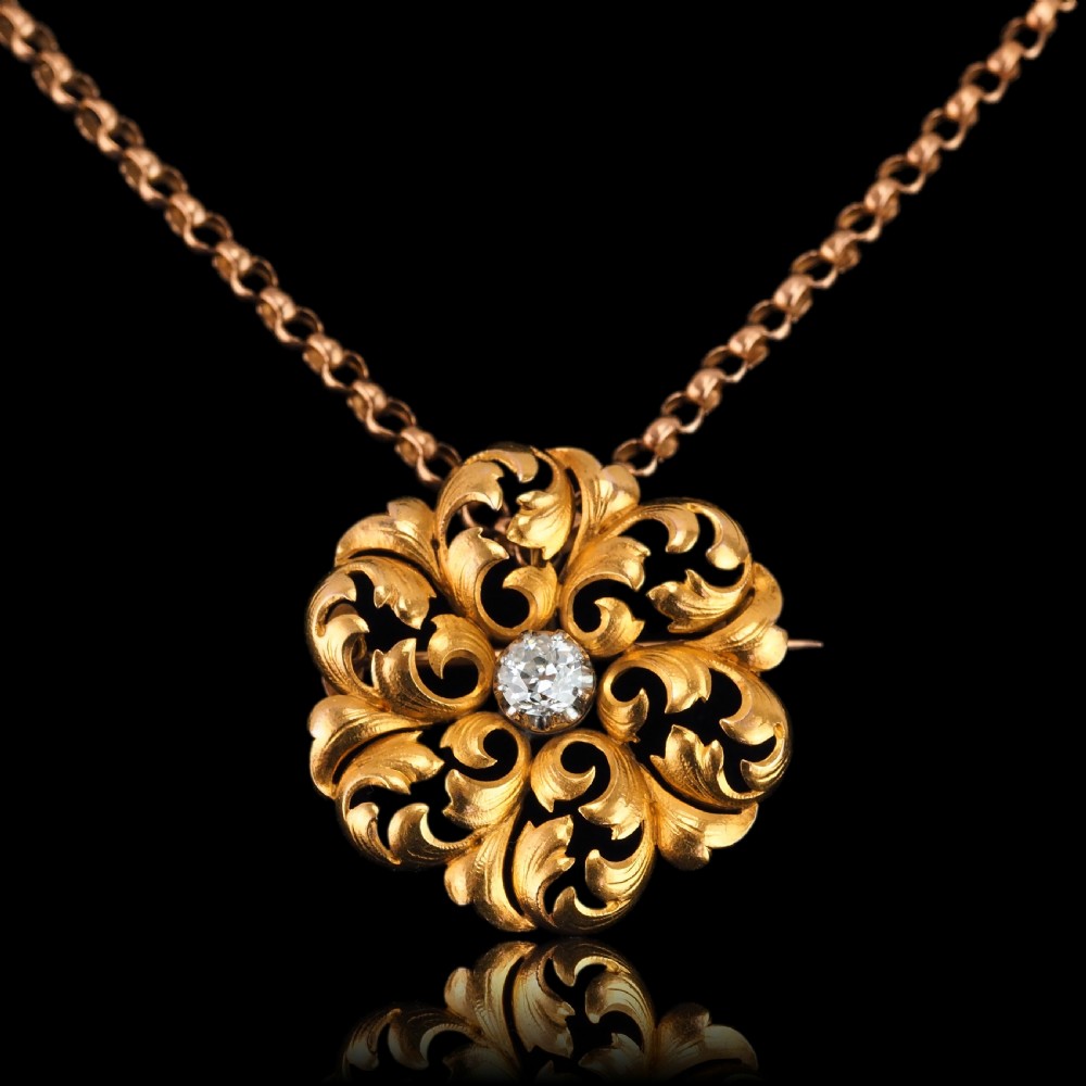 An 18ct yellow gold Victorian pendant brooch with openwork acanthus leaf scrollwork and a central round diamond. View XVII