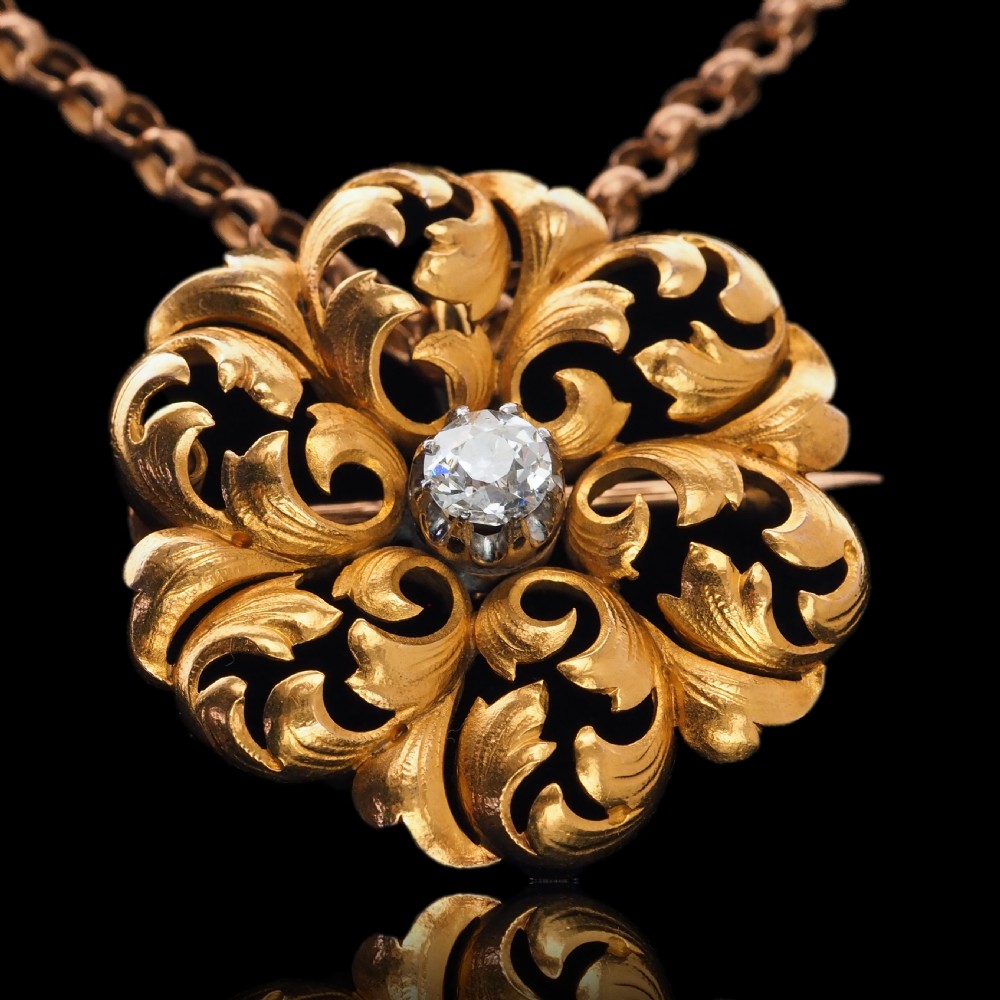 An 18ct yellow gold Victorian pendant brooch with openwork acanthus leaf scrollwork and a central round diamond. View XVIII