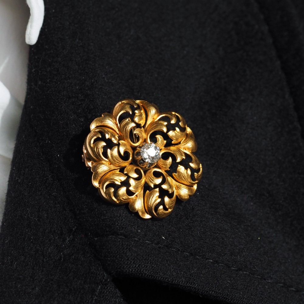 An 18ct yellow gold Victorian pendant brooch with openwork acanthus leaf scrollwork and a central round diamond. View XXI