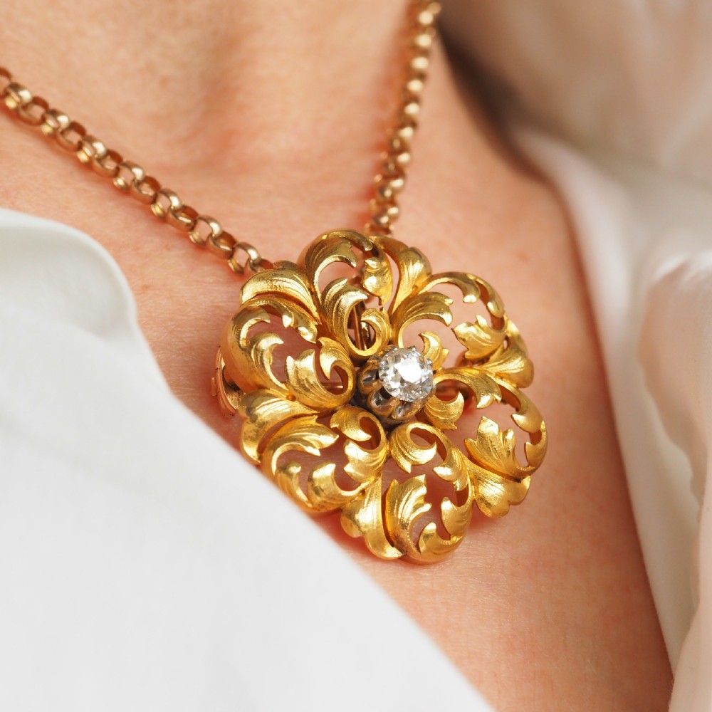An 18ct yellow gold Victorian pendant brooch with openwork acanthus leaf scrollwork and a central round diamond. View XXIII