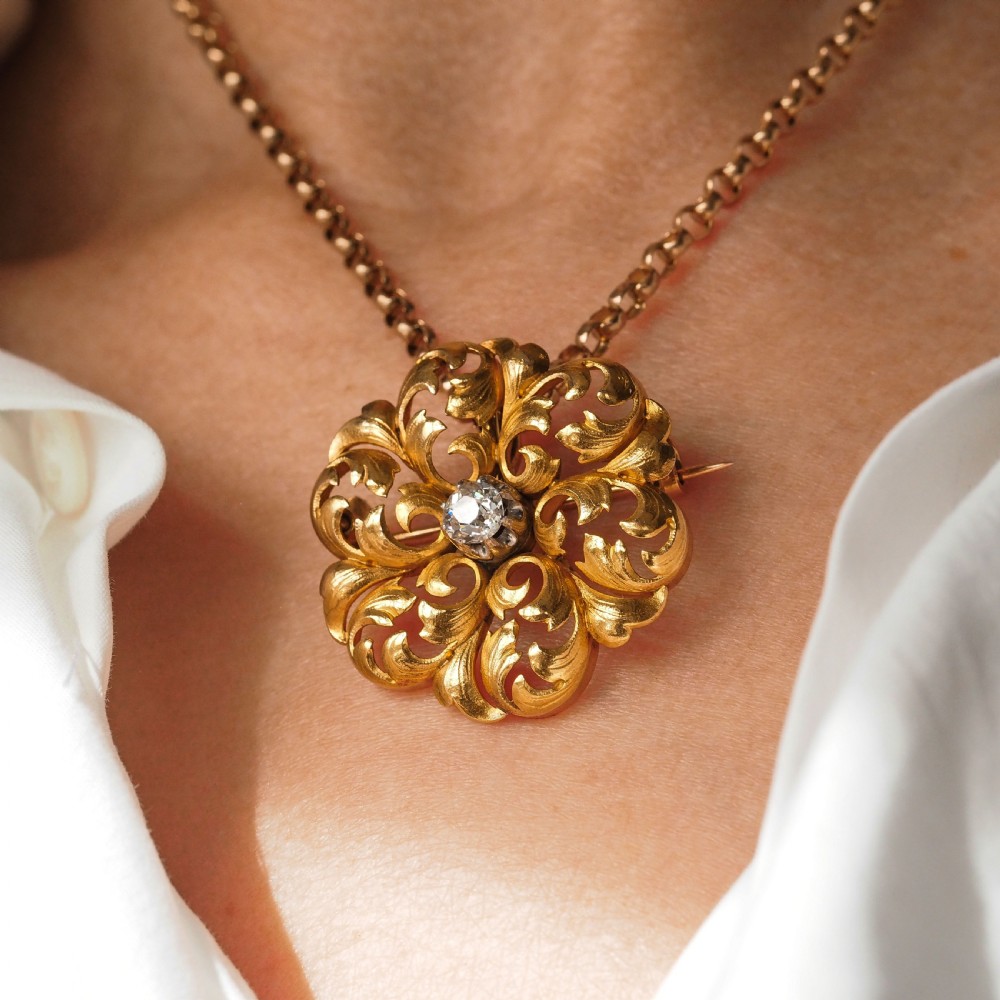 An 18ct yellow gold Victorian pendant brooch with openwork acanthus leaf scrollwork and a central round diamond. View XXV