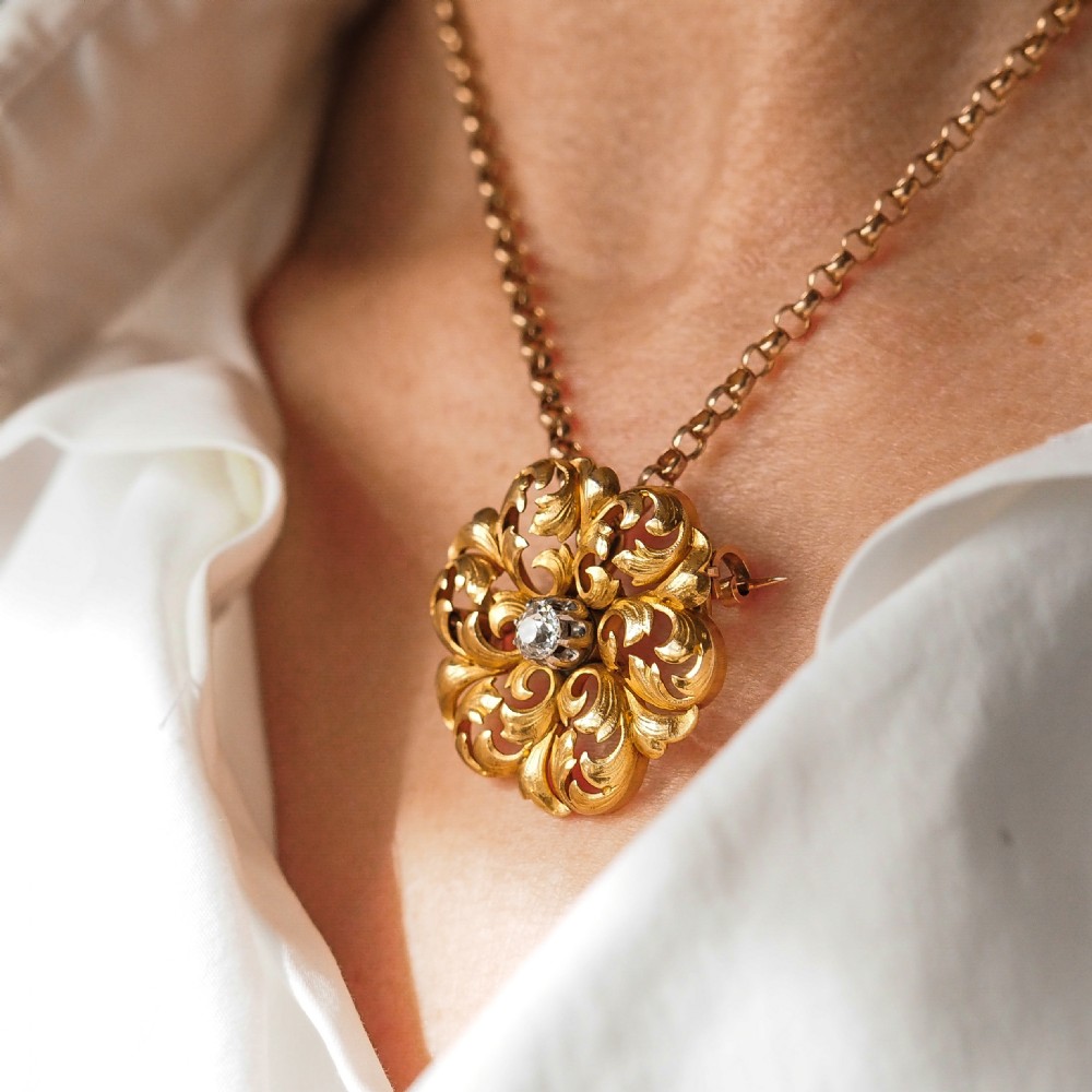An 18ct yellow gold Victorian pendant brooch with openwork acanthus leaf scrollwork and a central round diamond. View XXVI