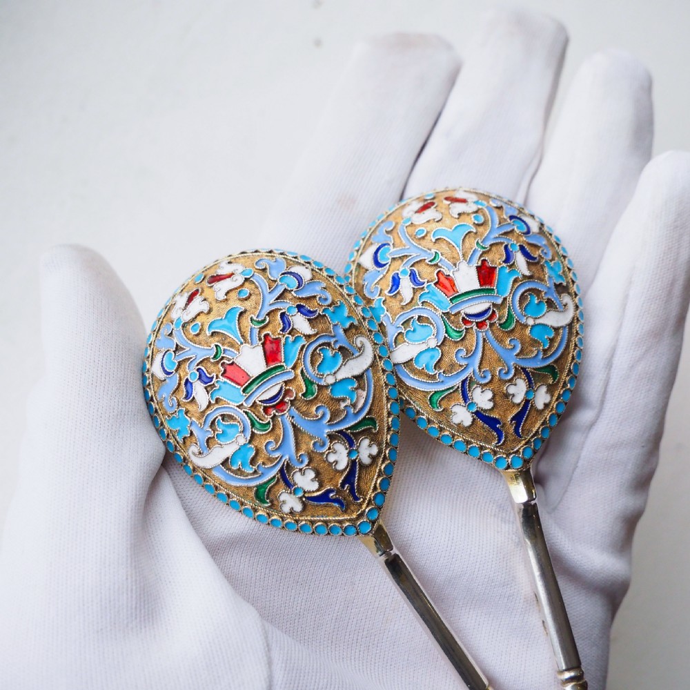 A pair of late nineteenth century Russian solid silver spoons featuring floral cloisonne enamel in turquoise, blue, red, and white on gilded teardrop bowls with twisted handles. View II