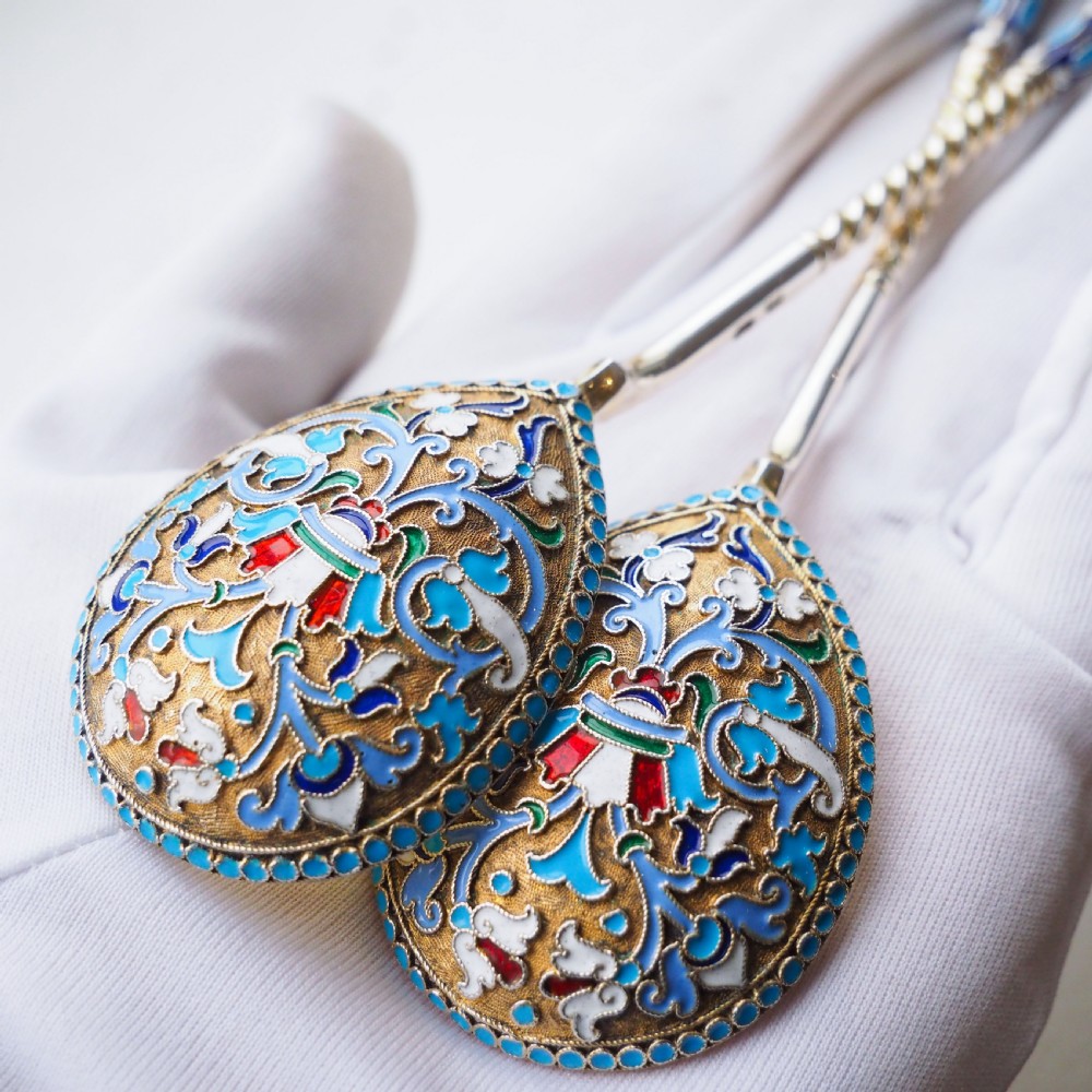 A pair of late nineteenth century Russian solid silver spoons featuring floral cloisonne enamel in turquoise, blue, red, and white on gilded teardrop bowls with twisted handles. View VI