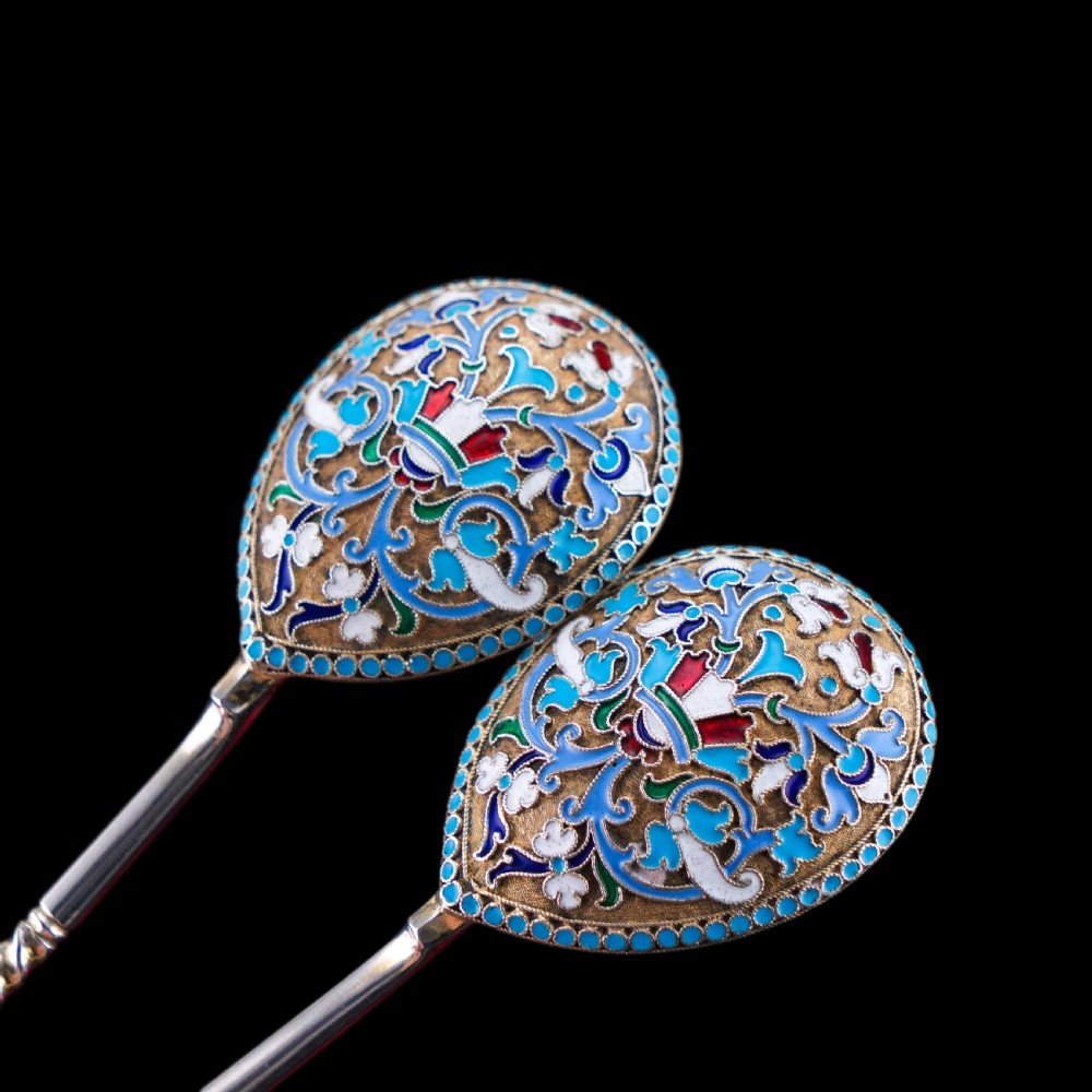 A pair of late nineteenth century Russian solid silver spoons featuring floral cloisonne enamel in turquoise, blue, red, and white on gilded teardrop bowls with twisted handles. View VII