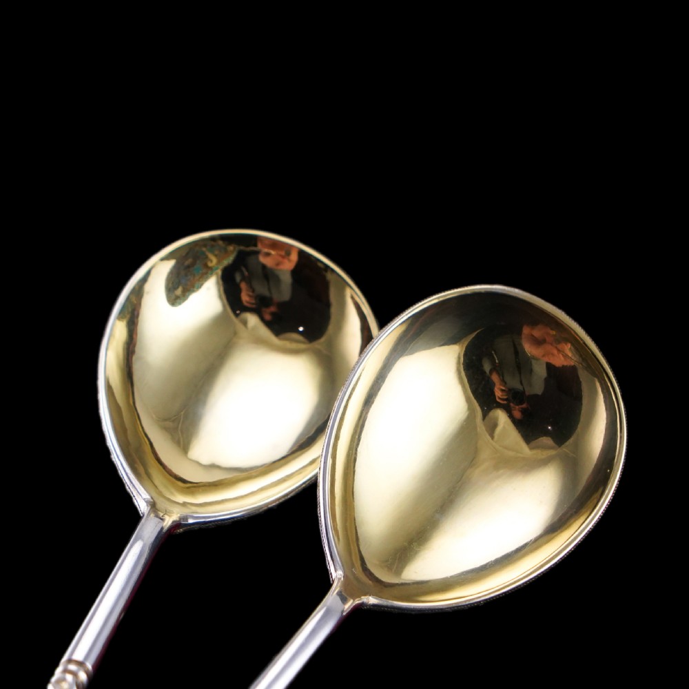 A pair of late nineteenth century Russian solid silver spoons featuring floral cloisonne enamel in turquoise, blue, red, and white on gilded teardrop bowls with twisted handles. View XV