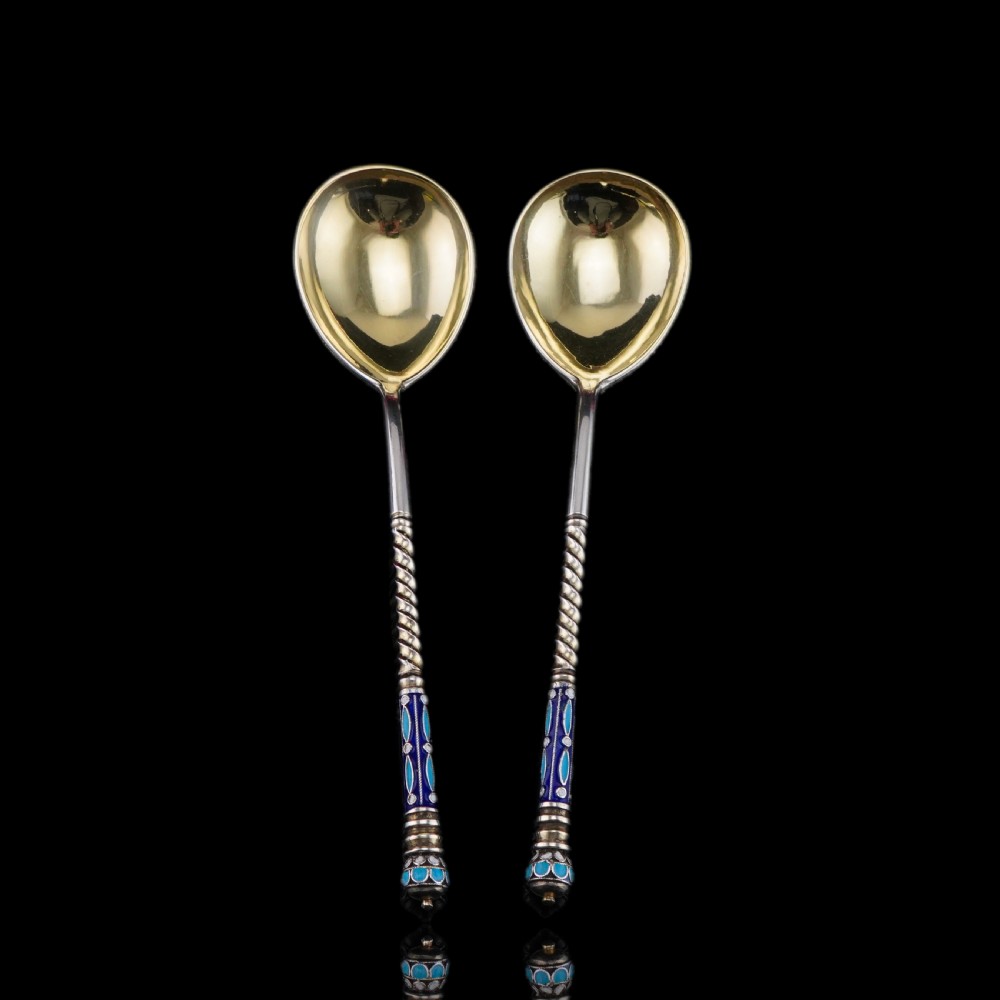 A pair of late nineteenth century Russian solid silver spoons featuring floral cloisonne enamel in turquoise, blue, red, and white on gilded teardrop bowls with twisted handles. View XVII