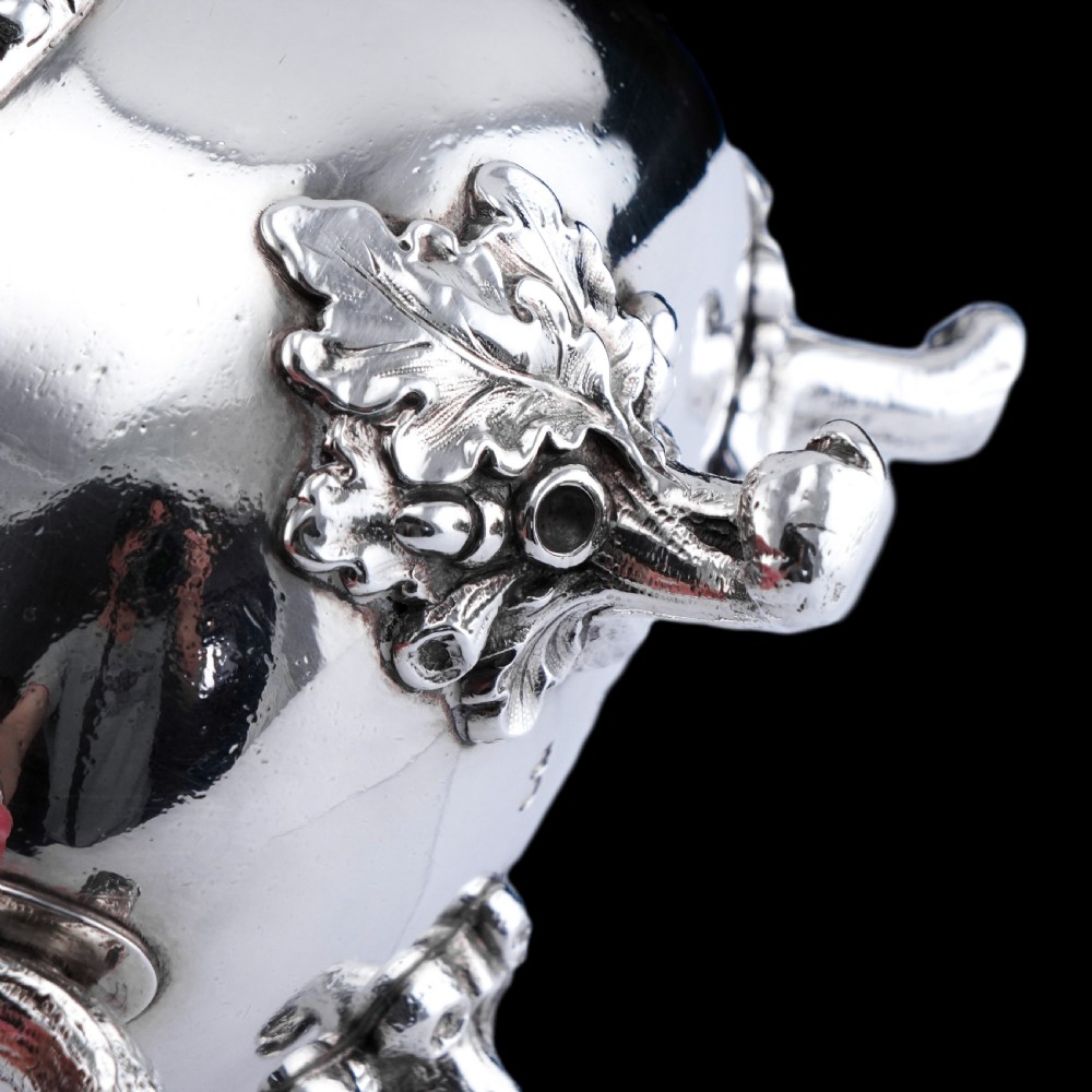 A Victorian sterling silver sauce boat featuring an organic twig handle, acorn feet, and engraved crest detailing. View IX