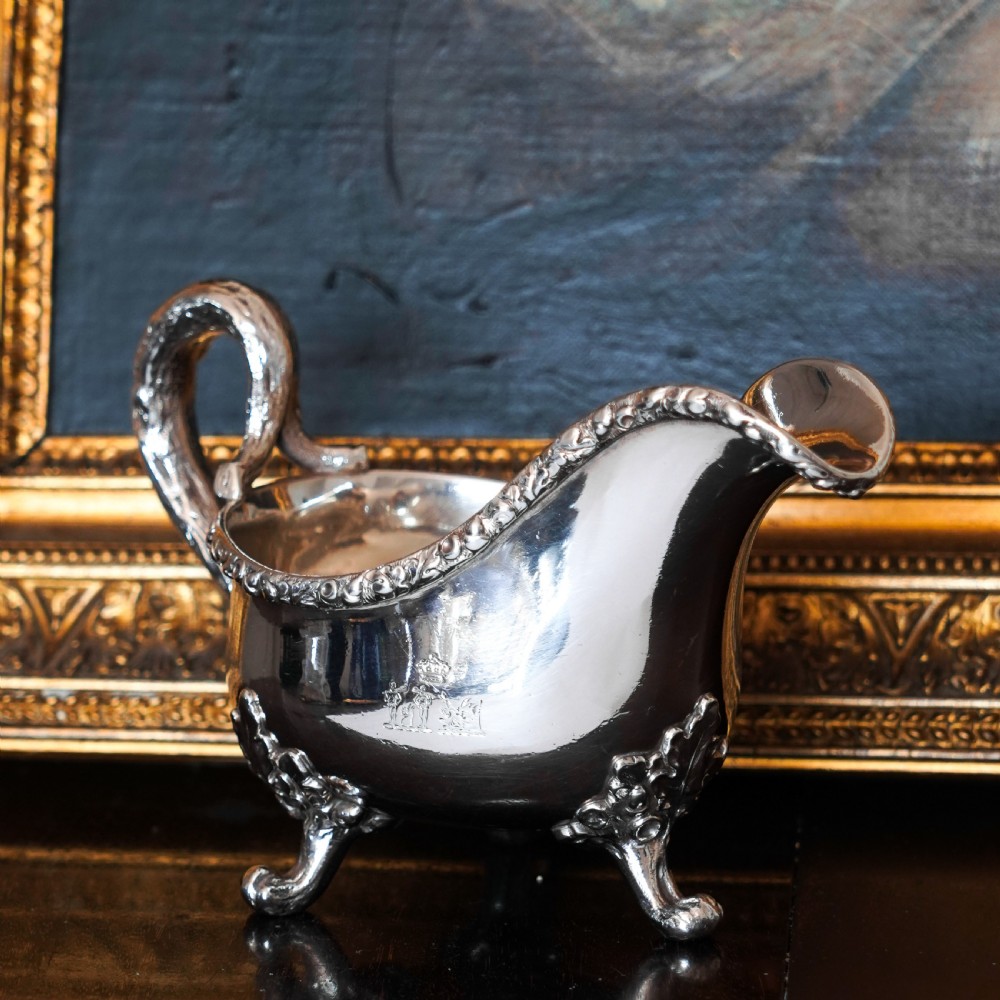 A Victorian sterling silver sauce boat featuring acorn and leaf feet, a branch-formed handle, and an engraved crest. View II