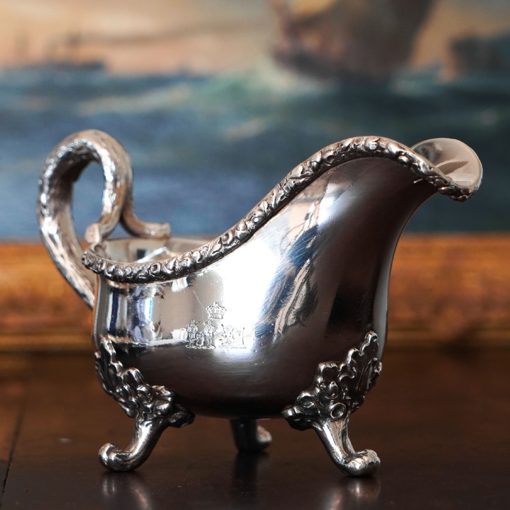 A Victorian sterling silver sauce boat featuring acorn and leaf feet, a branch-formed handle, and an engraved crest. View III
