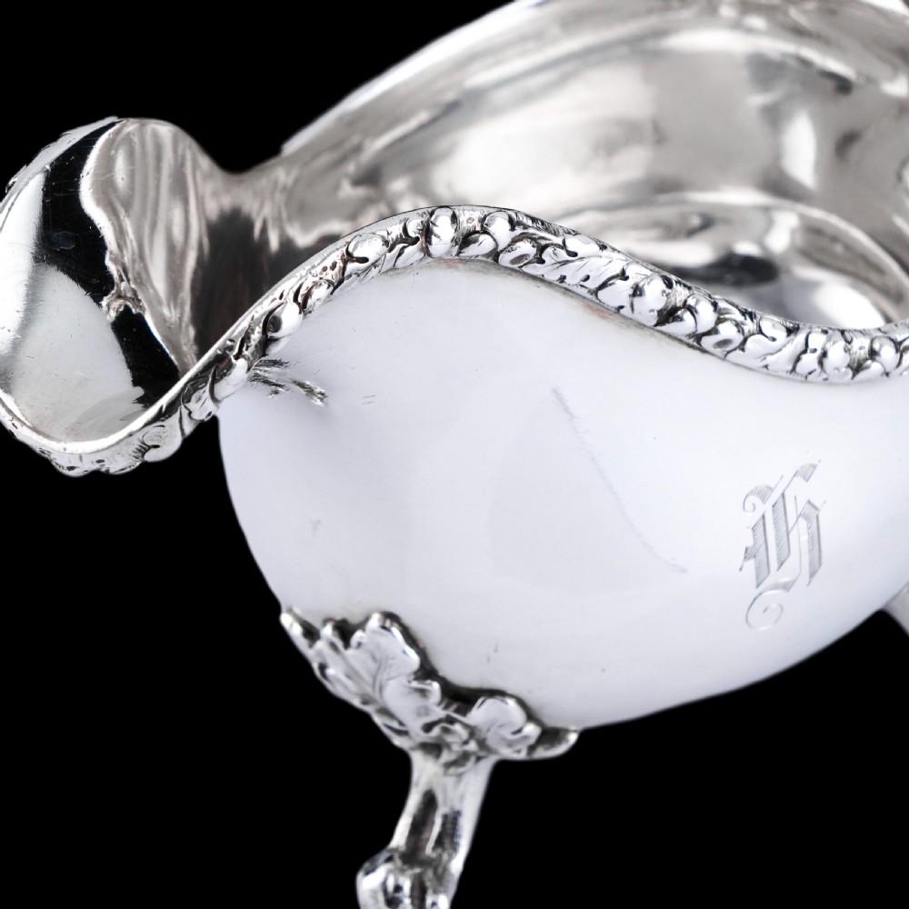 A Victorian sterling silver sauce boat featuring acorn and leaf feet, a branch-formed handle, and an engraved crest. View XII