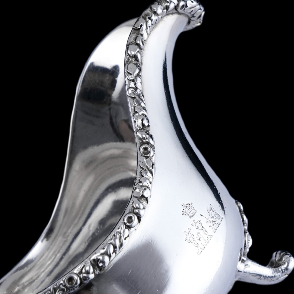 A Victorian sterling silver sauce boat featuring acorn and leaf feet, a branch-formed handle, and an engraved crest. View XVI