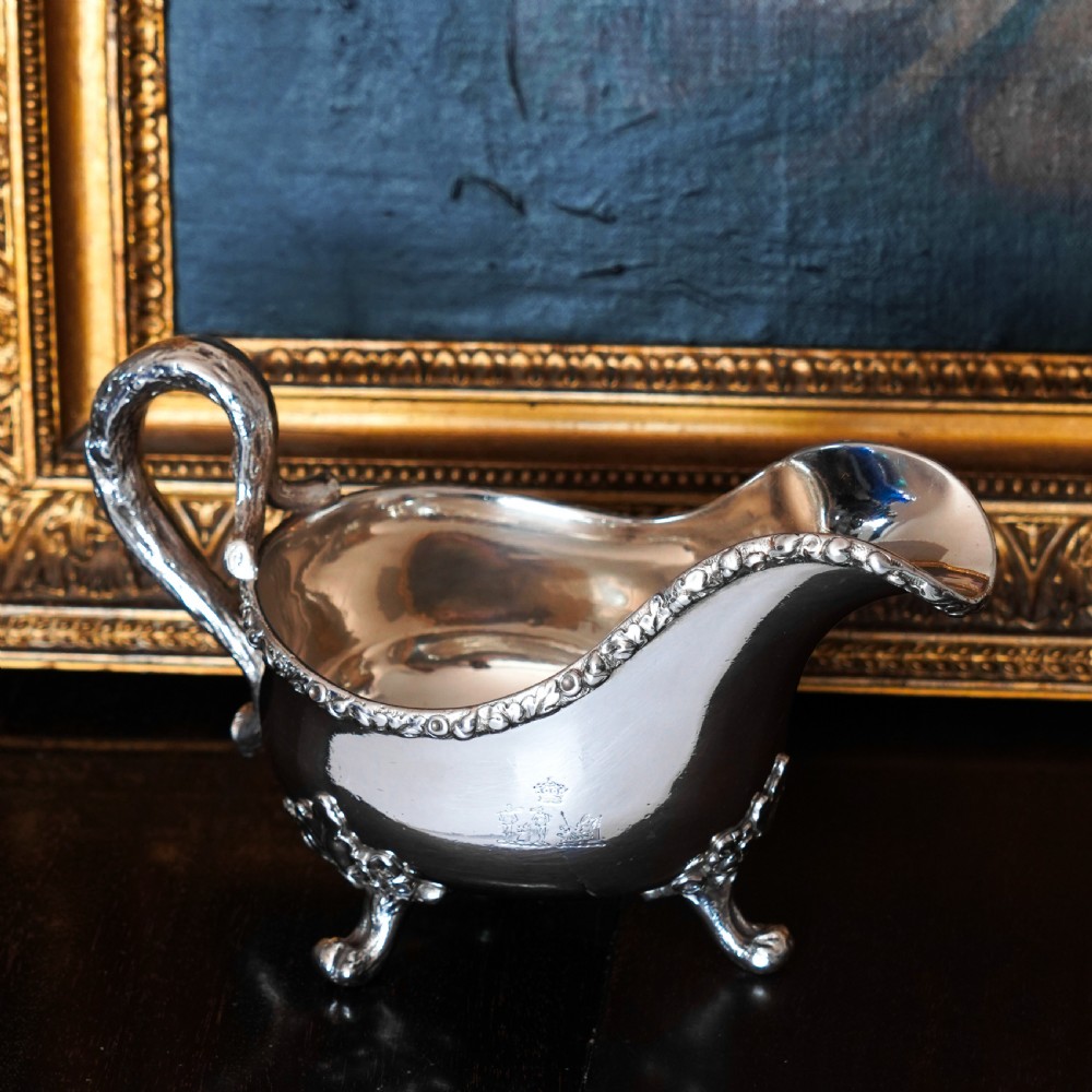A Victorian sterling silver sauce boat featuring acorn and leaf feet, a branch-formed handle, and an engraved crest. View XXIII