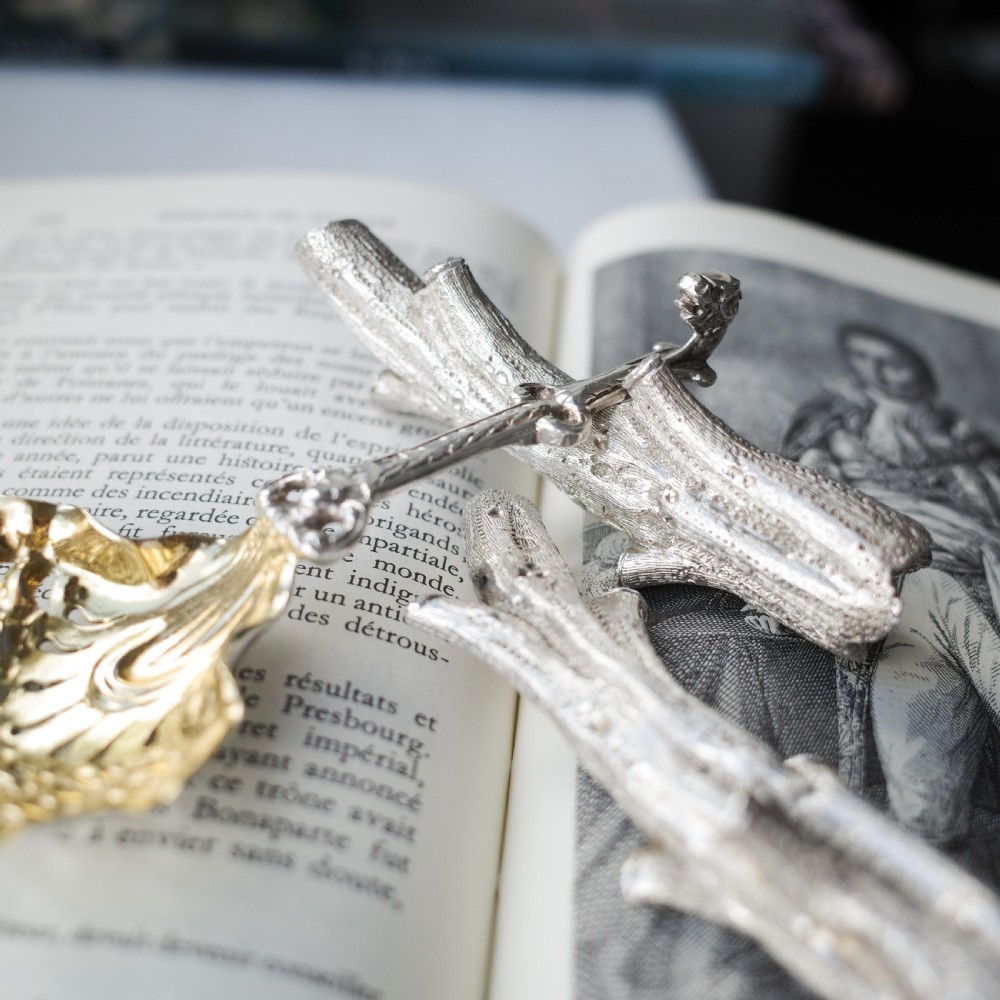 A detailed close-up of a Victorian solid silver knife rest fashioned in the shape of a textured tree branch. View VIII
