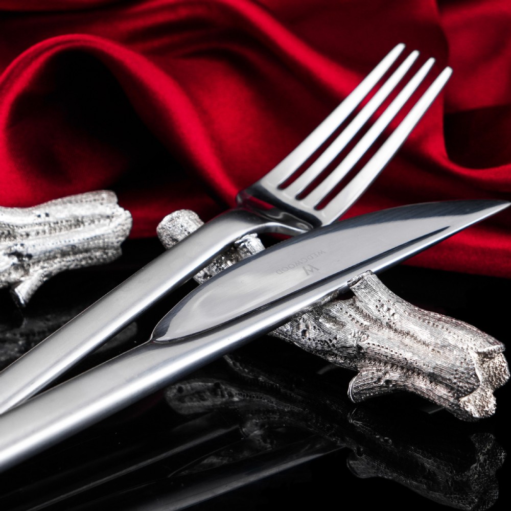 A detailed close-up of a Victorian solid silver knife rest fashioned in the shape of a textured tree branch. View XIX