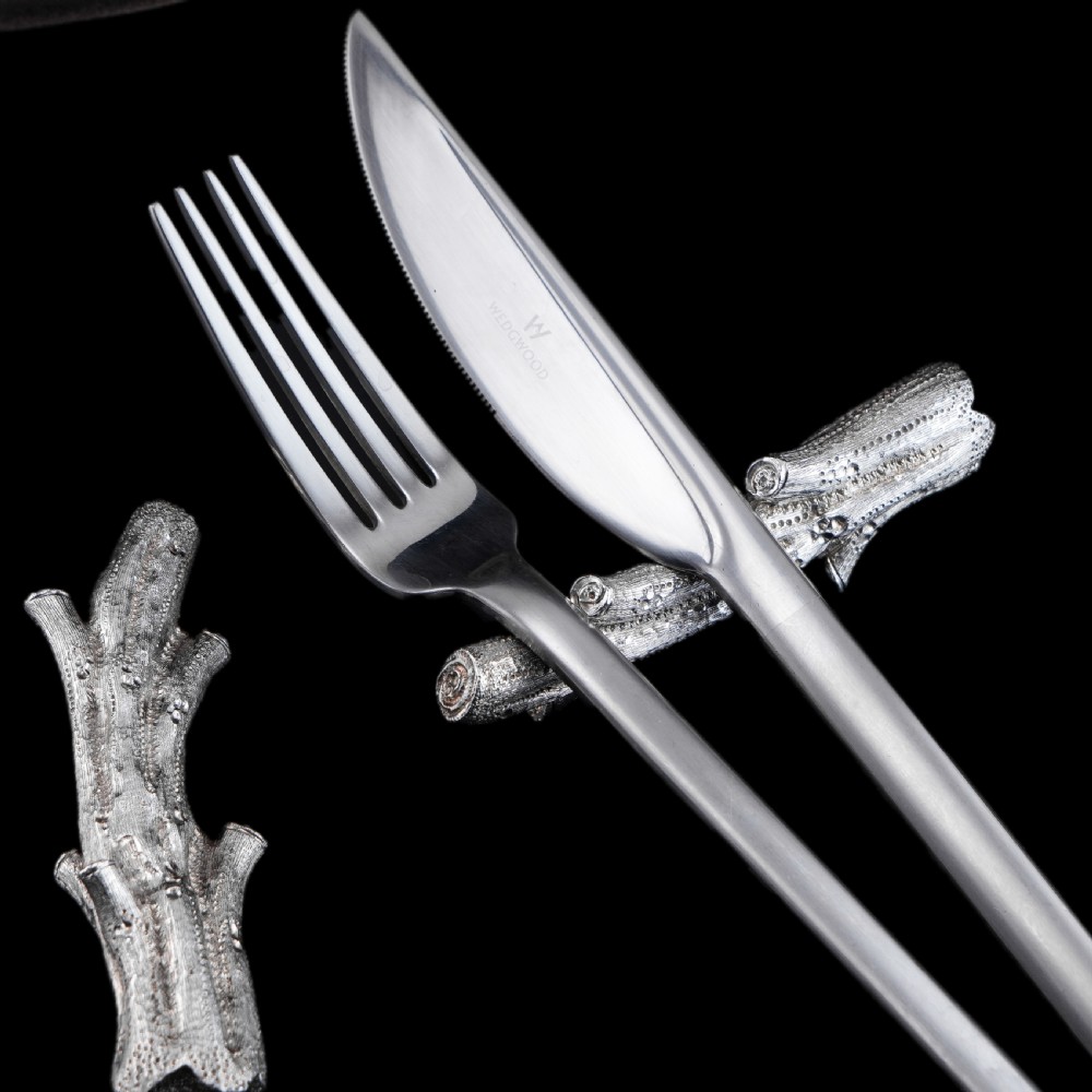 A detailed close-up of a Victorian solid silver knife rest fashioned in the shape of a textured tree branch. View XX