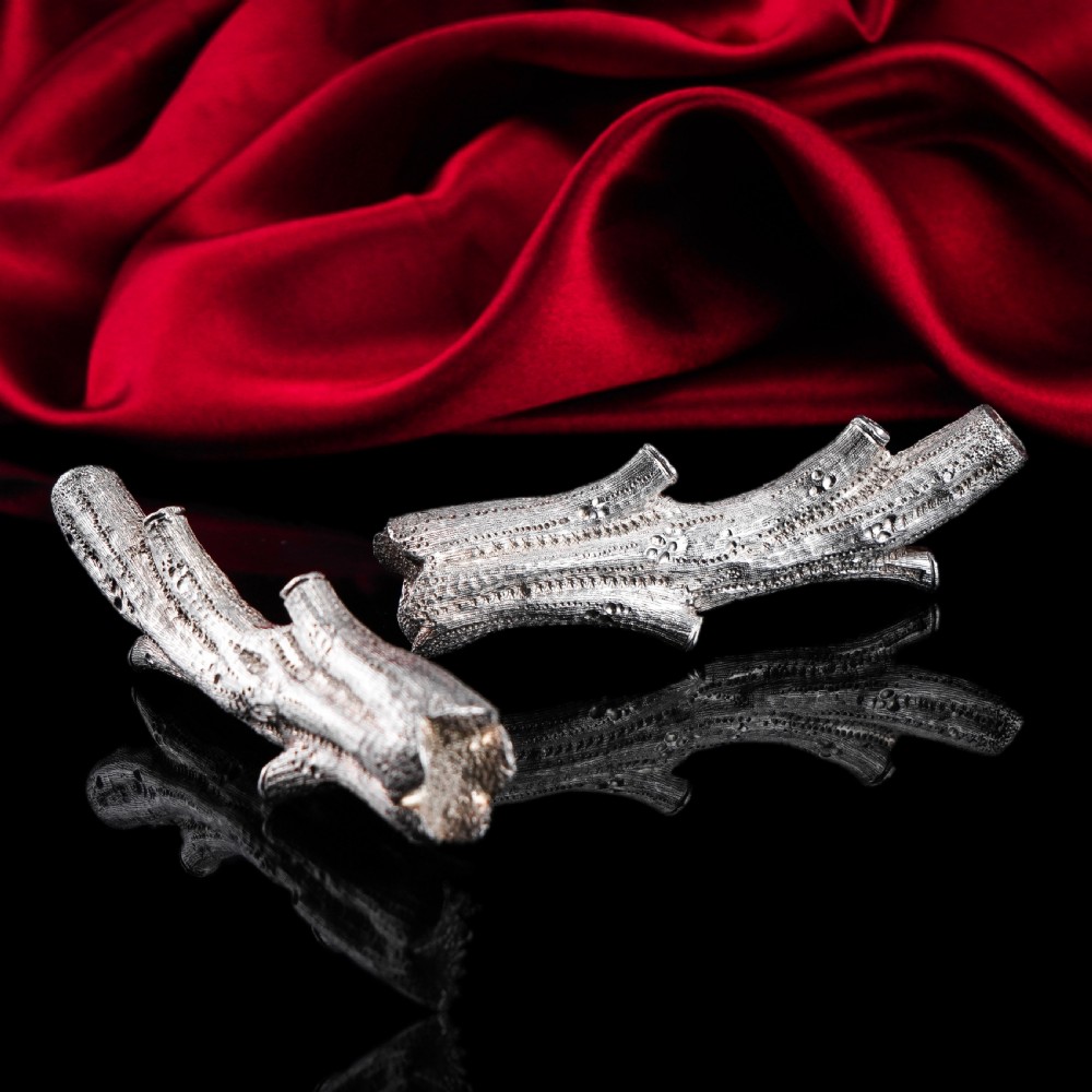 A detailed close-up of a Victorian solid silver knife rest fashioned in the shape of a textured tree branch. View XXI