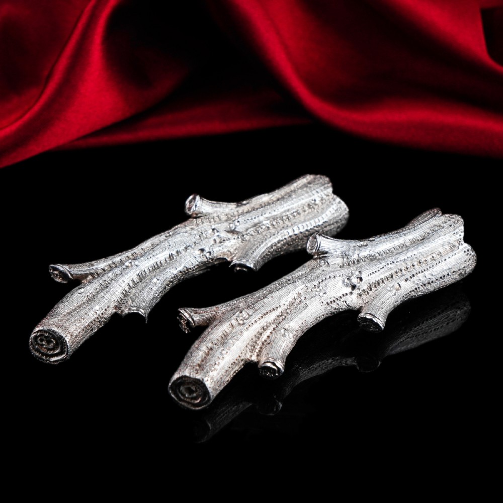 A detailed close-up of a Victorian solid silver knife rest fashioned in the shape of a textured tree branch. View XXII