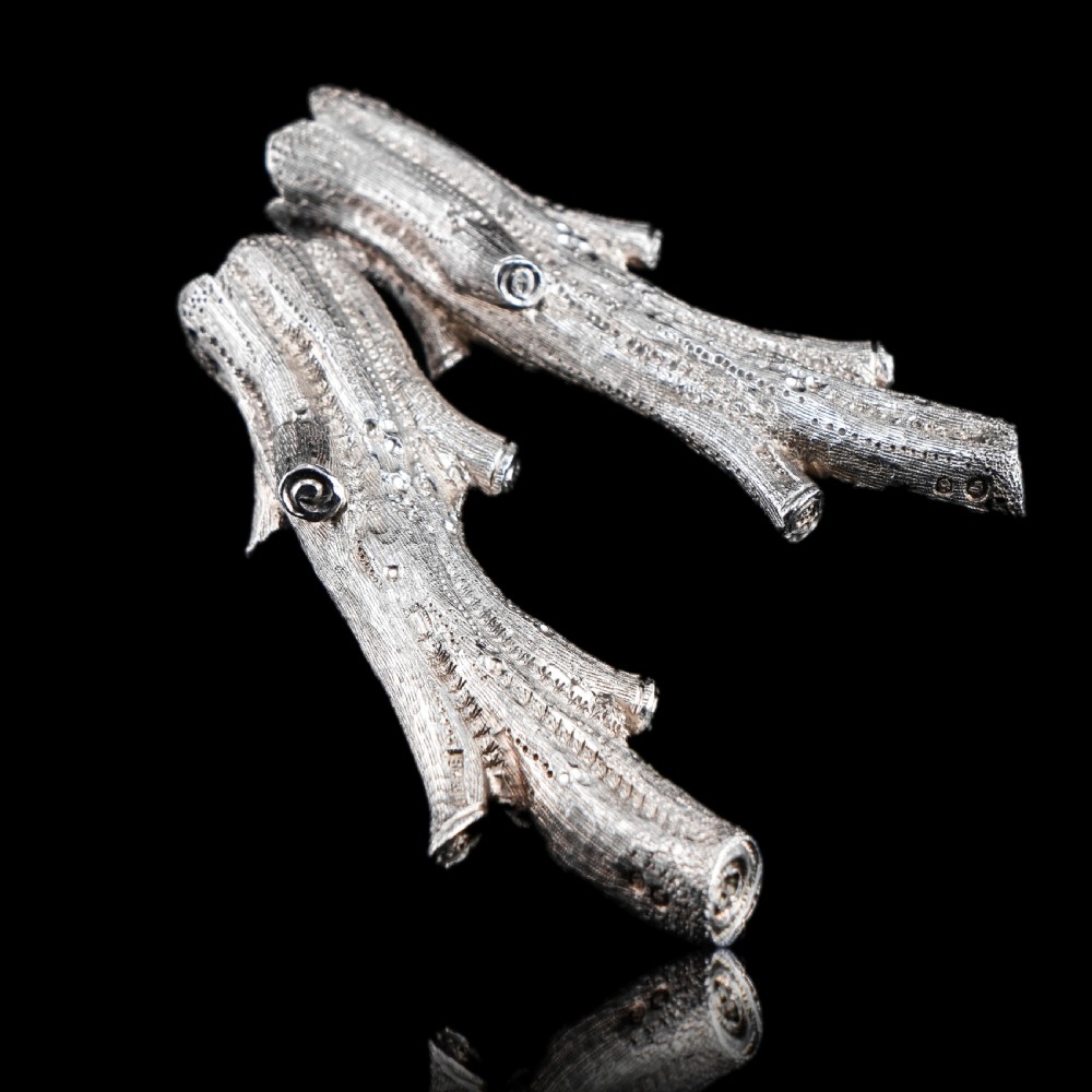 A detailed close-up of a Victorian solid silver knife rest fashioned in the shape of a textured tree branch. View XXIII