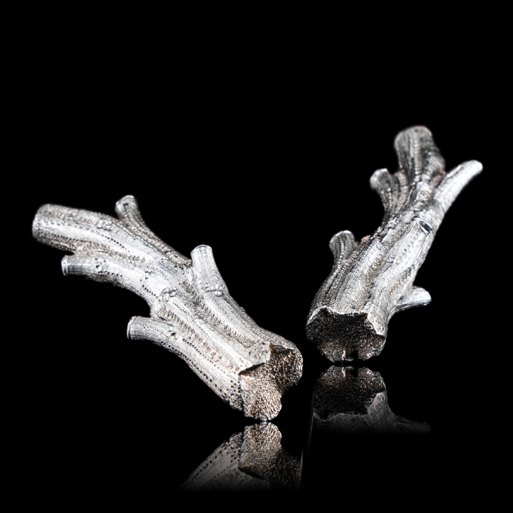 A detailed close-up of a Victorian solid silver knife rest fashioned in the shape of a textured tree branch. View XXV
