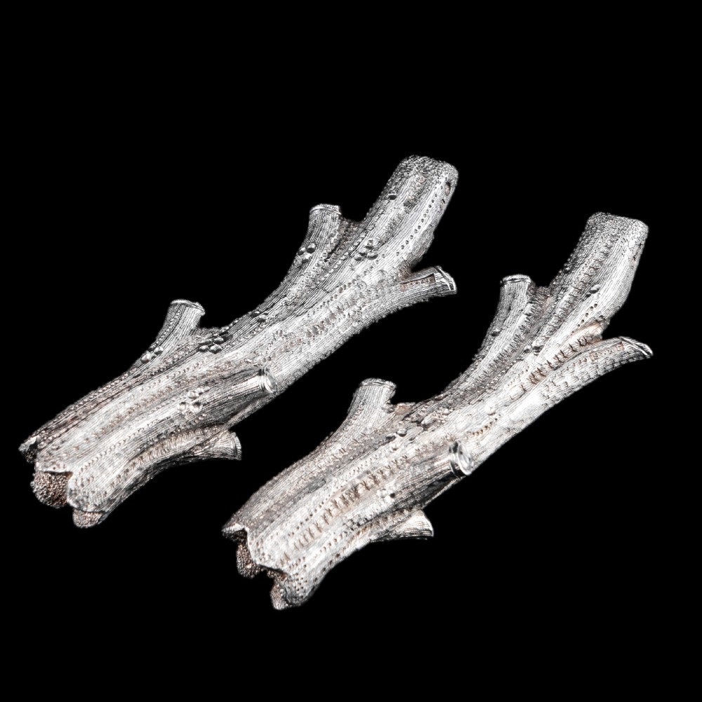A detailed close-up of a Victorian solid silver knife rest fashioned in the shape of a textured tree branch. View XXVI
