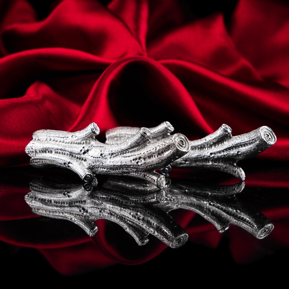 A detailed close-up of a Victorian solid silver knife rest fashioned in the shape of a textured tree branch. View XXVII