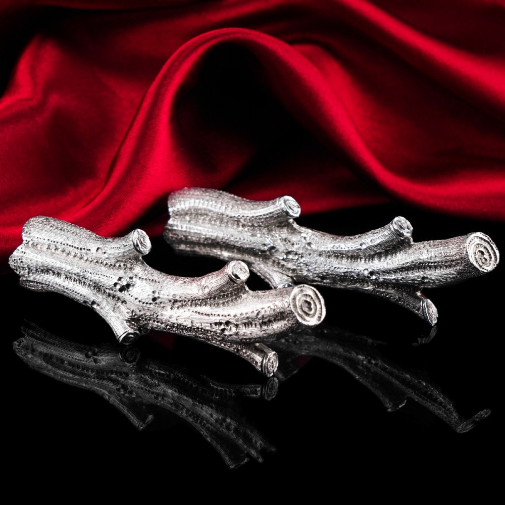 A detailed close-up of a Victorian solid silver knife rest fashioned in the shape of a textured tree branch. View XXVIII