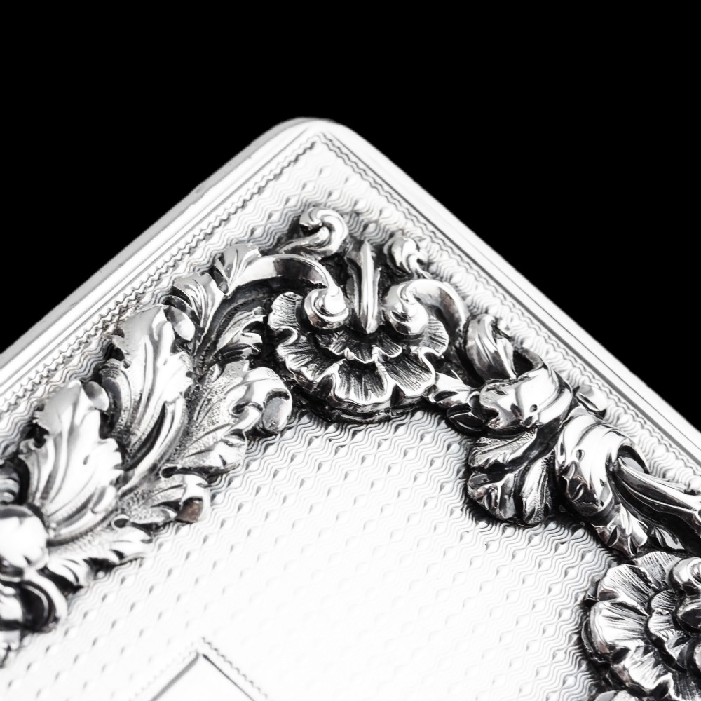 A rectangular Victorian sterling silver snuff box with an open hinged lid, engine-turned engraving, cast acanthus leaf border, and a gilt interior. View IX