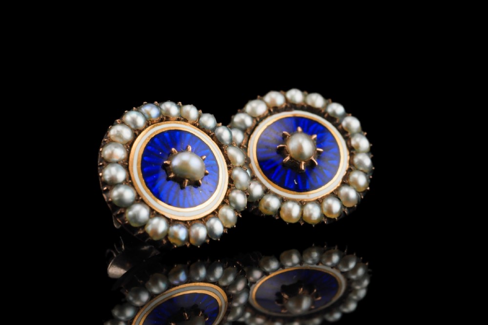 A pair of Georgian circular gold earrings featuring cobalt blue guilloche enamel centres surrounded by concentric rings of white enamel and seed pearls. View II