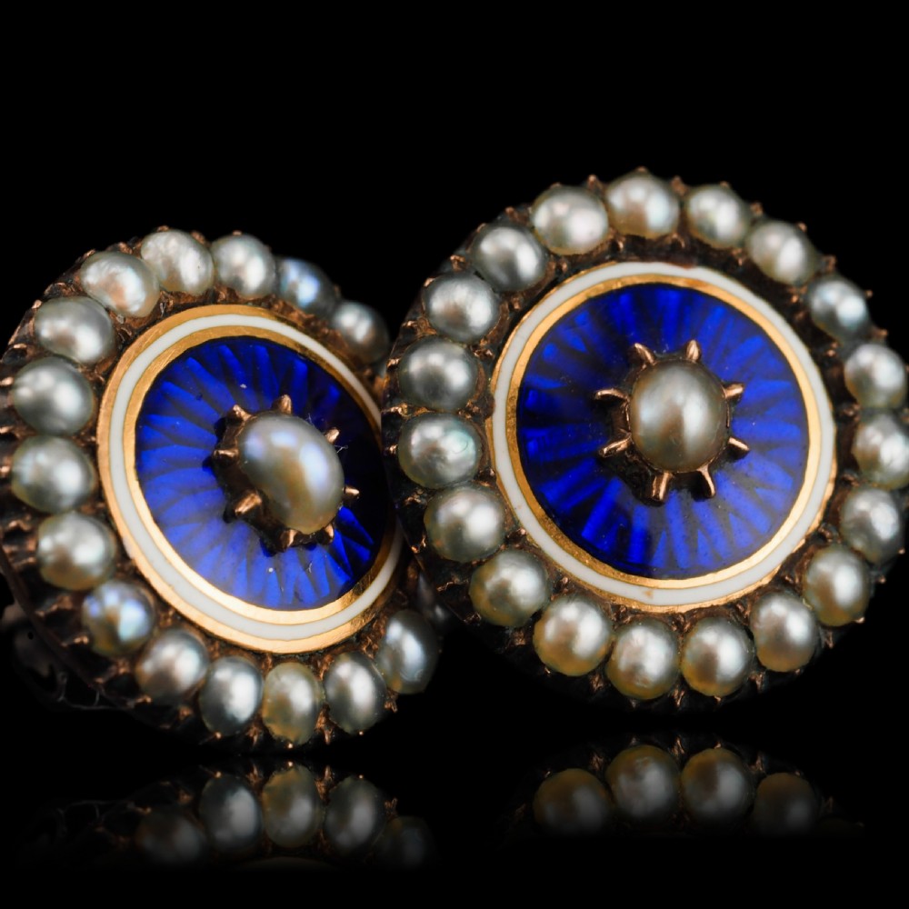 A pair of Georgian circular gold earrings featuring cobalt blue guilloche enamel centres surrounded by concentric rings of white enamel and seed pearls. View V