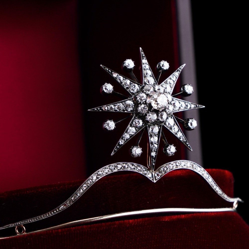 An antique Victorian diamond tiara featuring a central star motif set with old-cut diamonds mounted on a silver and gold frame.