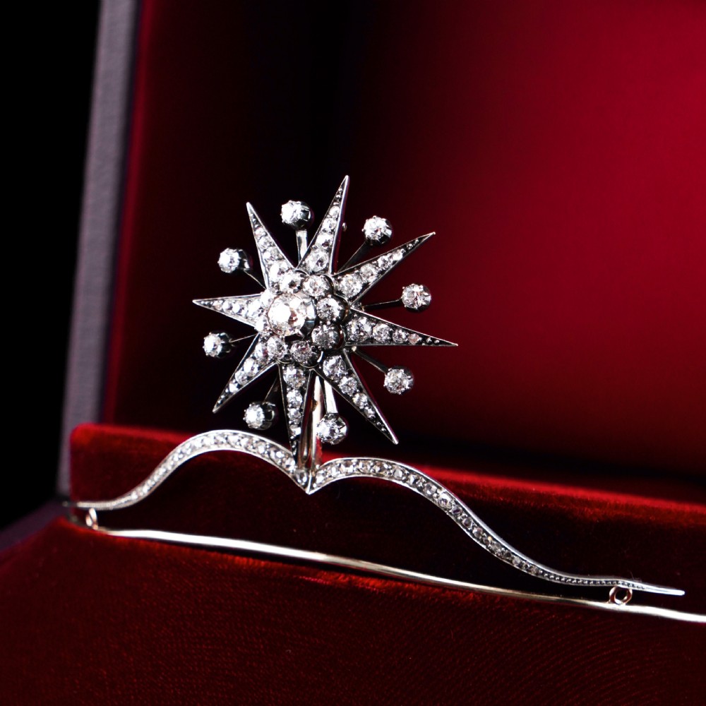 A Victorian diamond starburst tiara featuring a central starburst motif set with round cut diamonds above a sweeping diamond arch mounted on a fine metal headband. View V