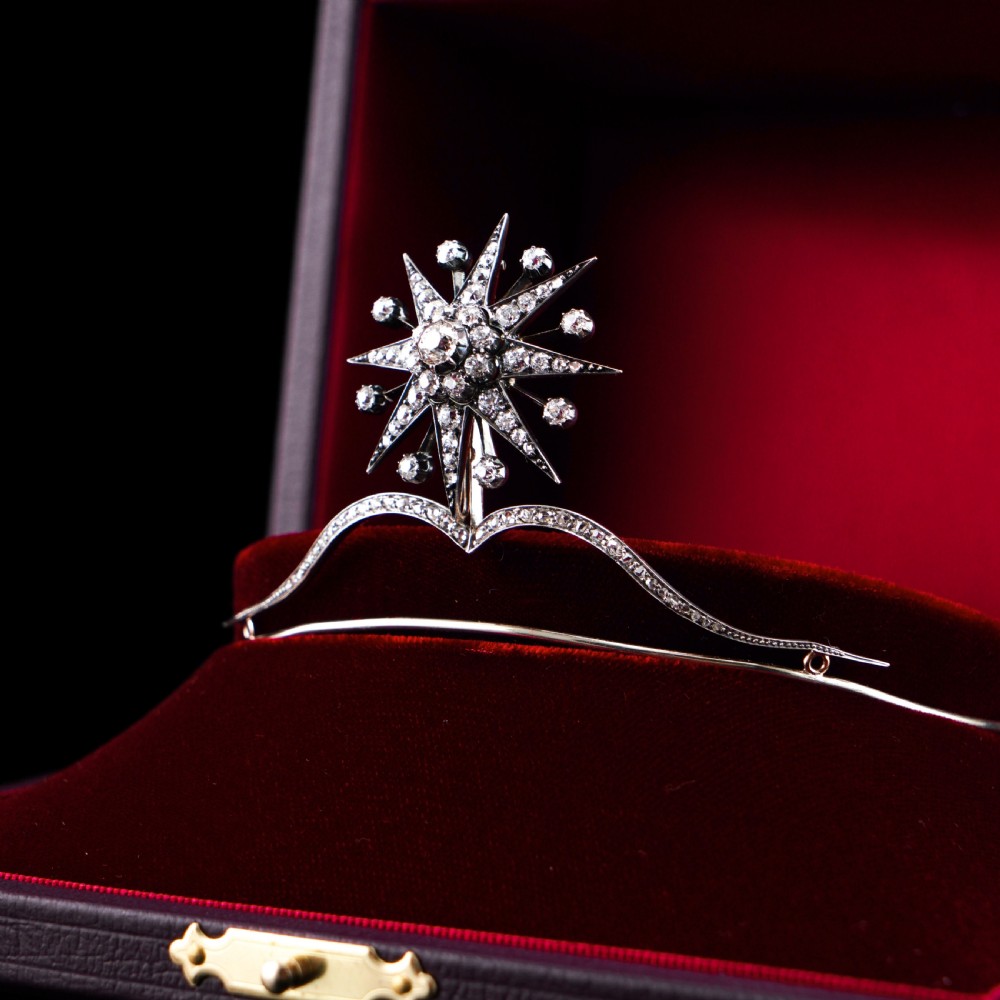 A Victorian diamond starburst tiara featuring a central starburst motif set with round cut diamonds above a sweeping diamond arch mounted on a fine metal headband. View VI